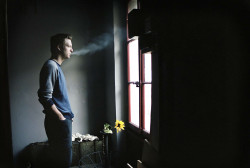 Man röker framför ett fönster. Fotograf: Susanne Kvarnlöf
